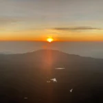 Sunrise above clouds and hills